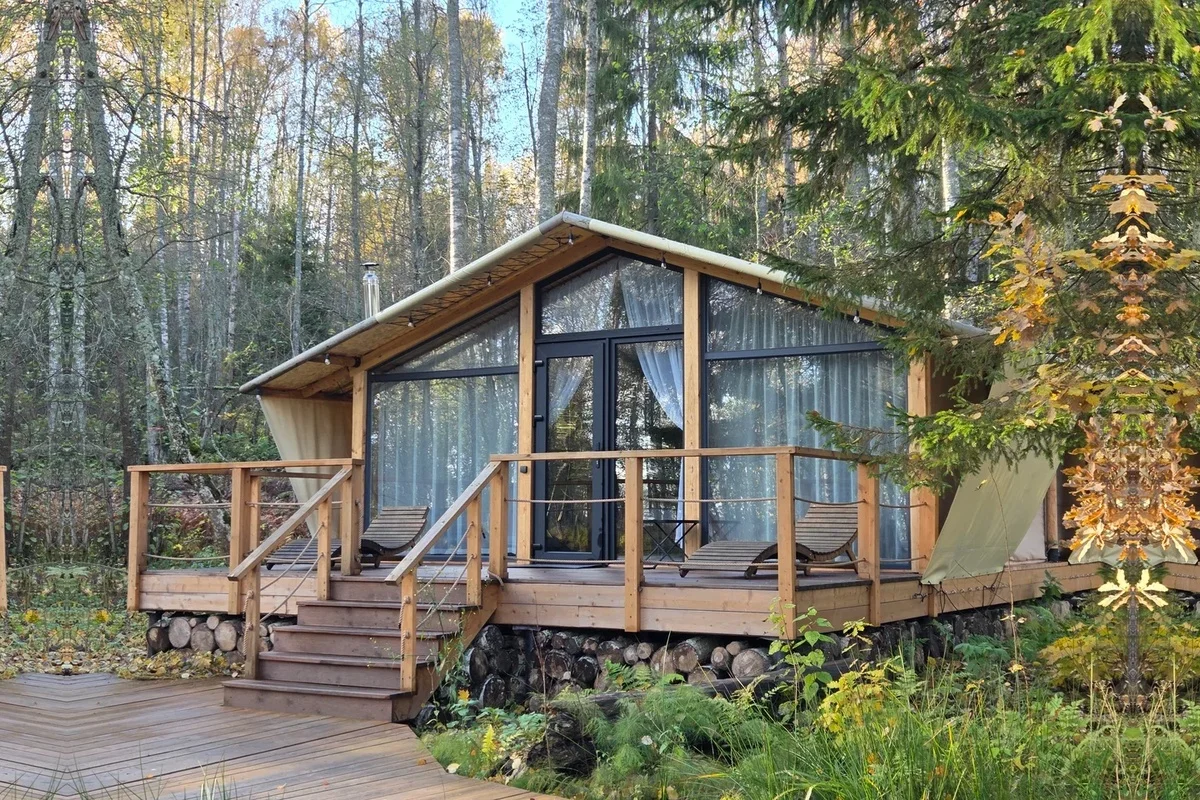 Porodični glamping objekat sa terasom u šumskom okruženju.